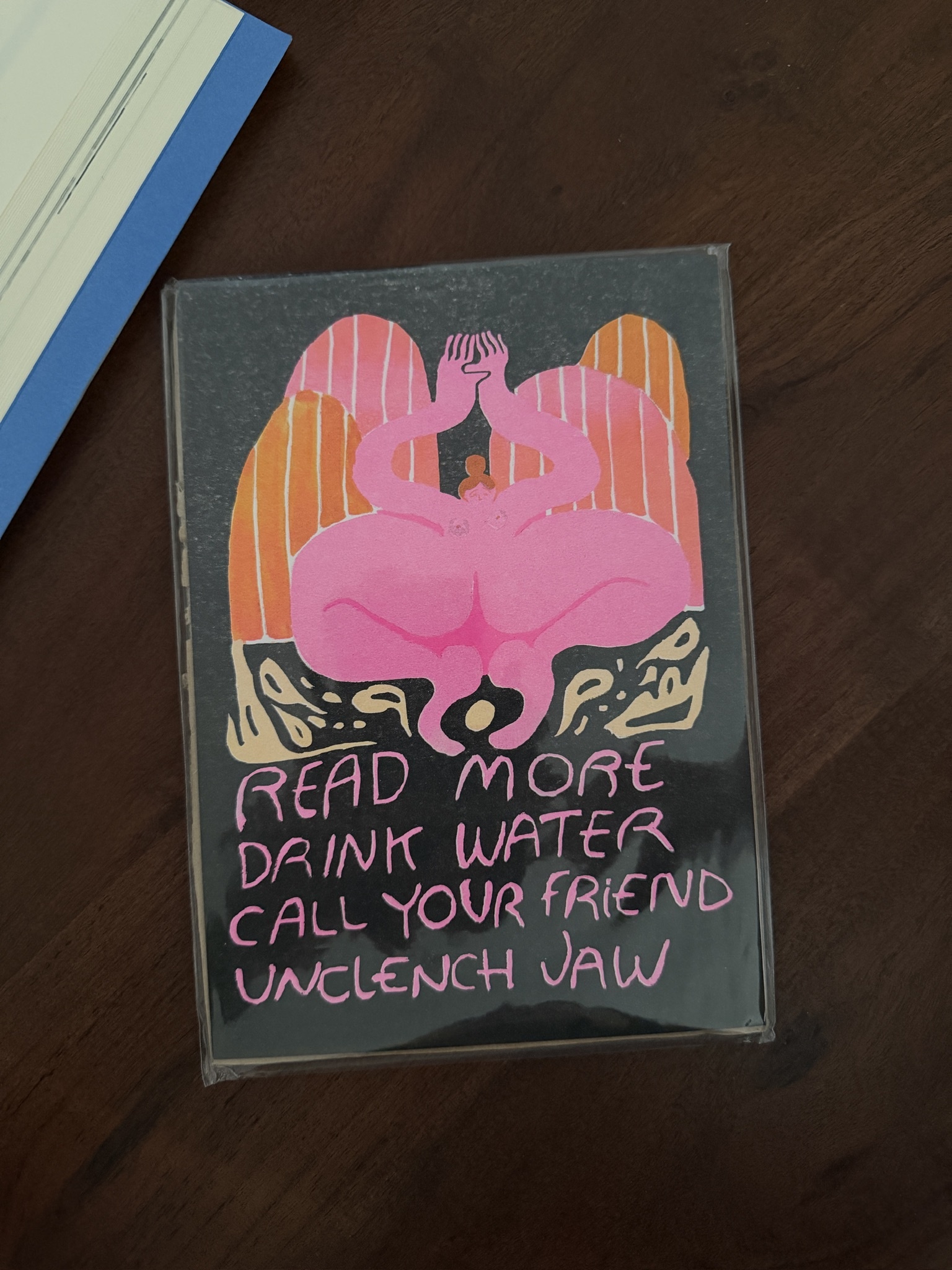 a pink illustrated print reading read more, drink water, call your friend, unclench jaw